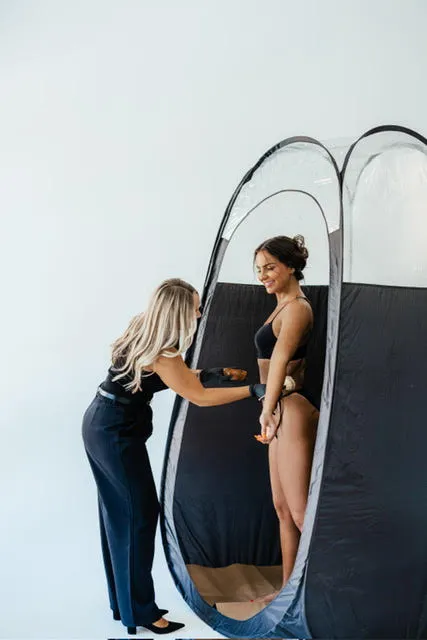 Coastal Bronze spray tan artist applying an airbrush tan